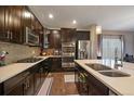 Modern kitchen with stainless steel appliances, quartz countertops, dark wood cabinetry, and a stylish backsplash at 5437 S Granby Ct, Aurora, CO 80015