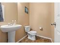 Charming half bath featuring a stylish pedestal sink and a tile floor at 9626 E 105Th Pl, Commerce City, CO 80640