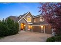 Charming home with stone accents, a three-car garage, and a well-manicured front yard with mature tree at 7284 Timbercrest Ln, Castle Pines, CO 80108