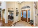 Grand entryway with hardwood floors, a decorative front door, and views into the dining room at 7284 Timbercrest Ln, Castle Pines, CO 80108