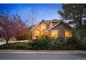 Charming two-story home with lush greenery and a stone-accented facade at 7284 Timbercrest Ln, Castle Pines, CO 80108