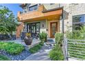 Modern front entrance with a wood door and a paved walkway leading to a patio at 1237 S Saint Paul St, Denver, CO 80210