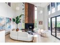 Bright living room with soaring ceilings, fireplace, and walls of windows at 12212 W 16Th Dr, Lakewood, CO 80215