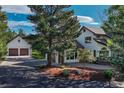 Elegant exterior view with a separate garage, lush landscaping, and a welcoming driveway at 2880 Lake Meadow Dr, Monument, CO 80132