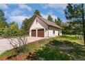 Detached two-car garage with matching roof tiles and plenty of surrounding greenery at 2880 Lake Meadow Dr, Monument, CO 80132