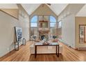 Bright living room featuring a stone fireplace, hardwood floors, and expansive arched windows at 2880 Lake Meadow Dr, Monument, CO 80132