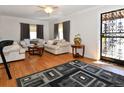 Sunlit living room featuring hardwood floors, plush sofas, neutral tones, and an ornate security door at 1765 S Franklin St, Denver, CO 80210