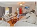 Spacious living room with hardwood floors, comfortable sofas, a flat-screen TV, and bright red door at 1765 S Franklin St, Denver, CO 80210