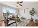 Stylish living room with a large window, a comfortable white sofa and hardwood floors at 9579 Bighorn Way, Littleton, CO 80125