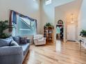 Bright and airy living room featuring high ceilings and elegant hardwood floors at 21220 E Nassau Ave, Aurora, CO 80013