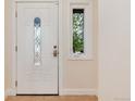 A beautiful front door with decorative glass and a sidelight window; the door is an inviting white at 3150 S Pitkin St, Aurora, CO 80013