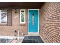 Close-up of the beautiful teal front door with decorative glass and a sidelight window on a brick home exterior at 3150 S Pitkin St, Aurora, CO 80013