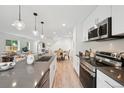 Modern kitchen features stainless steel appliances, sleek countertops, and open layout to the dining area at 5242 Columbine Ln, Denver, CO 80221