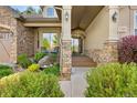 Inviting front porch with stone accents, decorative lighting, and space for seating at 3380 Quail Ct, Wheat Ridge, CO 80033