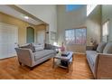 Inviting living room featuring hardwood floors, neutral decor, and plenty of natural light at 5338 Potentilla St, Brighton, CO 80601