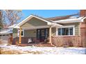 Inviting front exterior featuring a brick and siding facade, covered porch, and well-maintained landscaping at 1150 W Caley Ave, Littleton, CO 80120