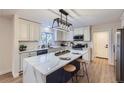 Spacious kitchen with an island, updated appliances, modern lighting, and bright, white cabinets and countertops at 1150 W Caley Ave, Littleton, CO 80120