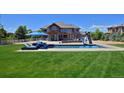 Aerial of backyard featuring a pool, slide, patio seating, and lush green lawn at 1315 W 141St Cir, Westminster, CO 80023