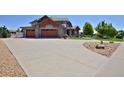 Exterior view of home with stone accents, three-car garage, and landscaped driveway at 1315 W 141St Cir, Westminster, CO 80023