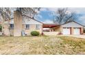 Back and side view of a ranch style brick home with a two-car garage and covered patio at 2300 Joliet St, Aurora, CO 80010