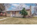 Charming single-story brick home featuring well-maintained lawn and cozy front porch at 2300 Joliet St, Aurora, CO 80010