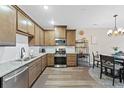 Well-lit kitchen with granite countertops, stainless appliances and wooden cabinets, plus modern pendant lighting at 23539 E Ida Dr # C, Aurora, CO 80016