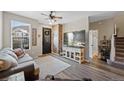 Inviting living room with plank floors, gray sofa, ceiling fan and decorative brick accent near the front door at 23539 E Ida Dr # C, Aurora, CO 80016