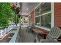 Relax on the cozy front porch with hanging flowers and comfortable seating at 2737 Ulster St, Denver, CO 80238