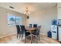 Dining room with wood table, six chairs, a chandelier, and a water cooler in the corner at 9943 Croke Dr, Denver, CO 80260