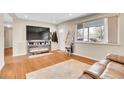 Comfortable living room with a fireplace, hardwood floors, and a large window at 8353 Adams Way, Denver, CO 80221