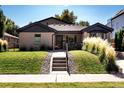 Inviting home features a well-kept lawn, decorative grasses, and a welcoming entrance at 3812 W 24Th Ave, Denver, CO 80211