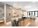 Spacious kitchen with an expansive island, stainless steel appliances, and stylish modern lighting fixtures at 417 N Madison St, Denver, CO 80206