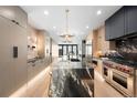 Bright, open kitchen featuring a marble island, stainless steel appliances, and modern pendant lighting fixtures at 417 N Madison St, Denver, CO 80206