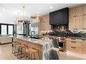 Contemporary kitchen with a large island, modern appliances, stylish lighting, and a sleek black marble backsplash at 417 N Madison St, Denver, CO 80206