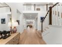 Bright entryway featuring hardwood floors, staircase, and an open view into the living spaces at 15 Latigo Pl, Littleton, CO 80123