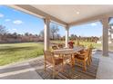 Covered patio features an outdoor dining area with views of the backyard and playground at 15 Latigo Pl, Littleton, CO 80123