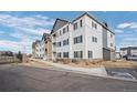 Attractive multi-story building with gray and white exterior, landscaped grounds, and ample parking at 15700 E Jamison Dr # 8-208, Englewood, CO 80112