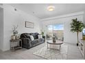 Bright living room featuring comfortable seating, stylish decor, and a sliding door to the balcony at 15700 E Jamison Dr # 8-208, Englewood, CO 80112