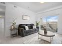 Cozy living room featuring a comfortable sofa, stylish decor, and a balcony with scenic views at 15700 E Jamison Dr # 8-208, Englewood, CO 80112