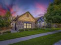 Beautiful exterior elevation showcases the home's stone accents, manicured lawn, and lush landscaping at 1020 S Ammons Cir, Lakewood, CO 80226