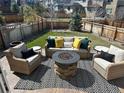 Cozy backyard featuring a stone fire pit, comfortable seating, and a well-maintained lawn at 3173 Youngheart Way, Castle Rock, CO 80109
