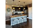 Charming kitchen featuring dark cabinets, granite counters, stainless steel appliances, and a kitchen island at 3173 Youngheart Way, Castle Rock, CO 80109