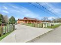 Long concrete driveway leading to a ranch home with a white horse fence at 5365 Eldridge St, Arvada, CO 80002