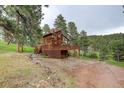 A charming mountain home with a wrap-around deck, and a drive-under garage at 13190 Coyote Song Trl, Conifer, CO 80433