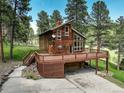 Mountain home with wrap-around deck, drive-under garage, surrounded by mature trees at 13190 Coyote Song Trl, Conifer, CO 80433