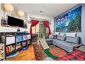 Cozy living room with a large window, plush sofa, and a television at 4100 Albion St # 612, Denver, CO 80216