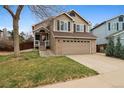 Inviting two-story home featuring a two-car garage, classic architecture, and well-manicured lawn at 6425 Nassau Ct, Highlands Ranch, CO 80130