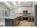 Bright kitchen featuring stainless steel appliances, granite countertops, and skylights at 6425 Nassau Ct, Highlands Ranch, CO 80130