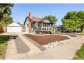 Exterior shot showing the front of the house with a detached garage and gravel driveway at 3755 S Sherman St, Englewood, CO 80113
