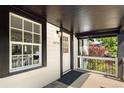 Covered front porch with white railing, black trim, and views of the landscaped front yard at 3755 S Sherman St, Englewood, CO 80113